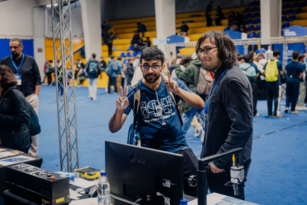 Alumno saludando a la cámara frente al stand de ARTIUC