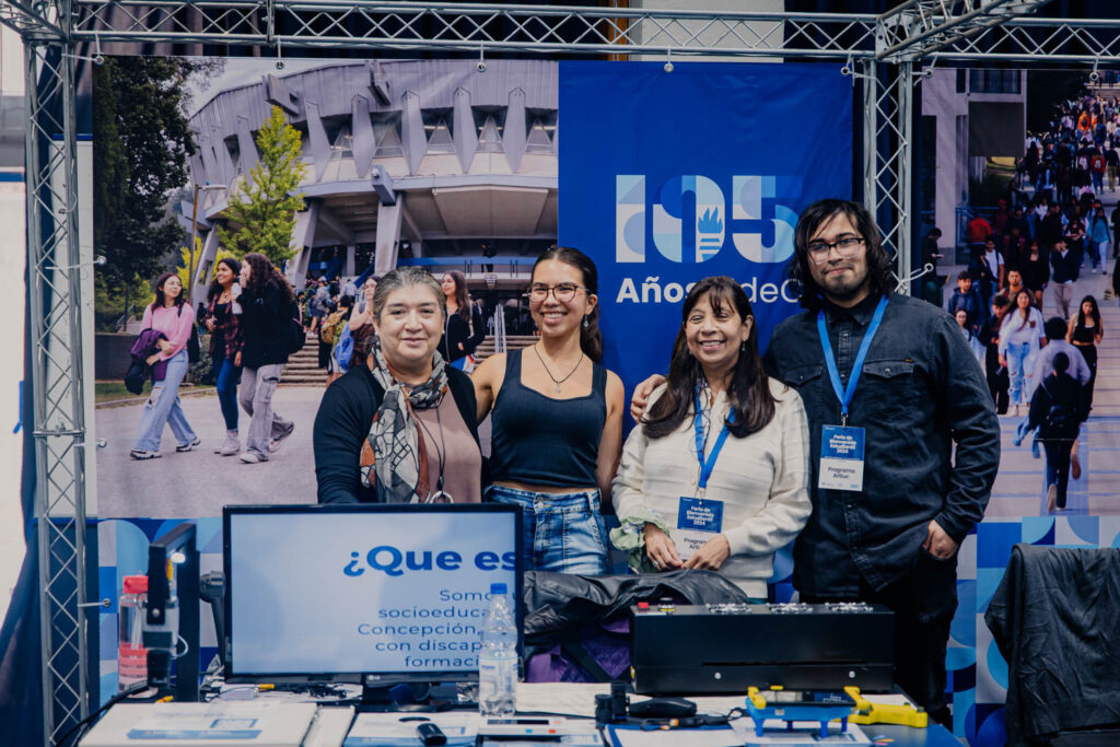 Equipo de ARTIUC con dos de sus estudiantes, quienes participaron como ponentes en el stand de la feria de postgrado.