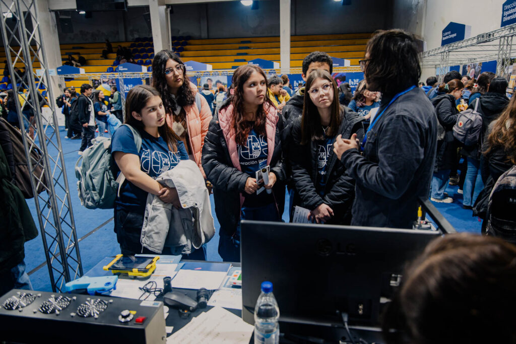 Grupo de estudiantes mujeres frente al stand de Artiuc.